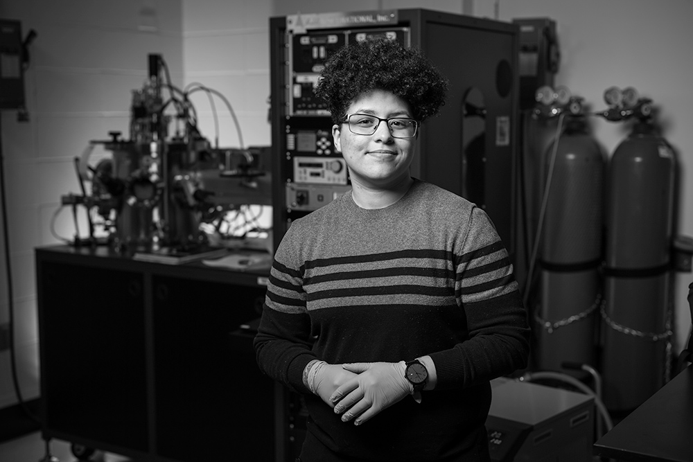 student surrounded by electrical equipment in lab.