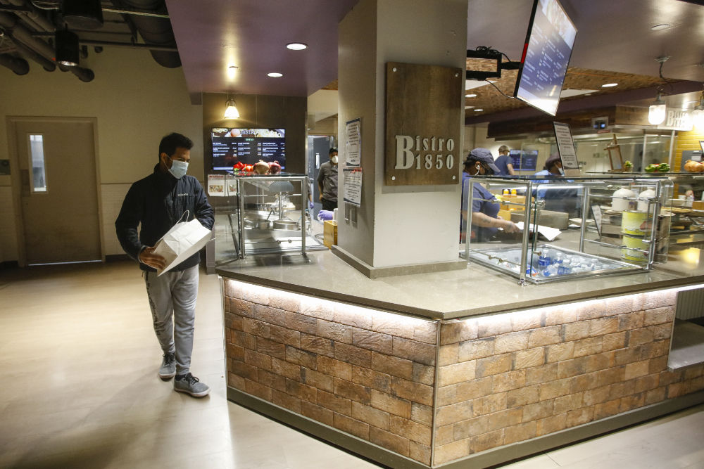 Heri Rajaoberison '22 carries a to-go bag to pick up lunch at the Bistro 1850 serving station.