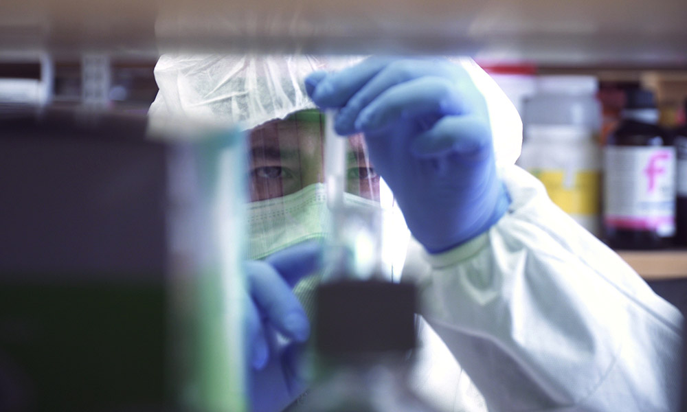 person in protective gear examining something he is holding