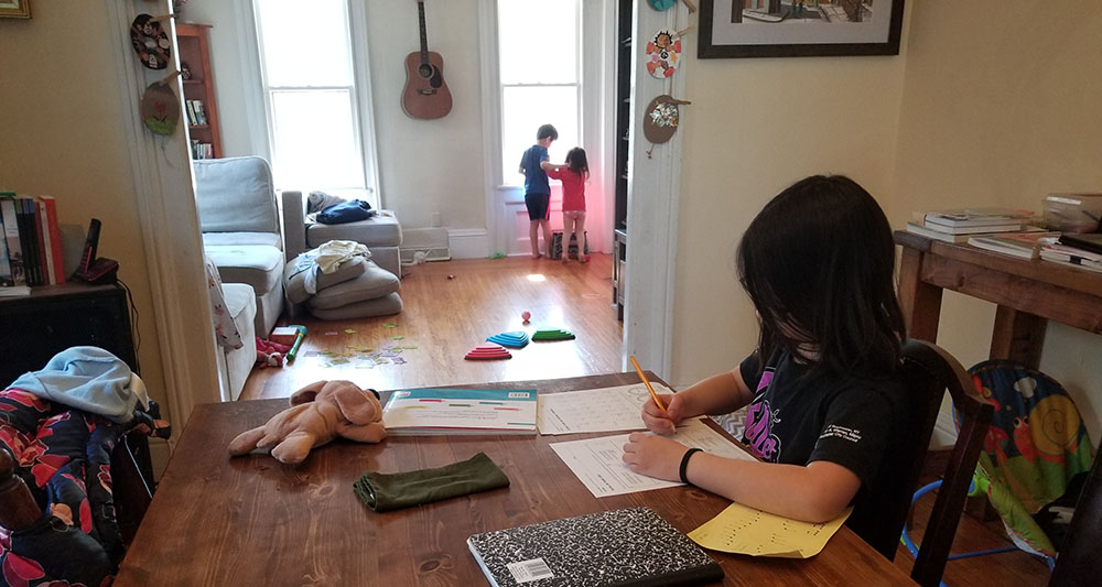 child seated at table writing