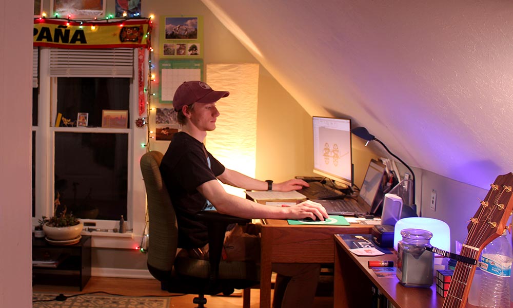 student sitting in his attic at a computer