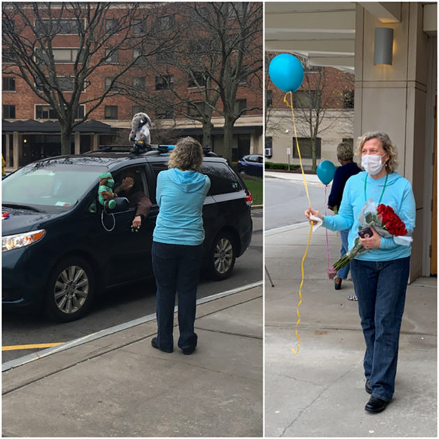 nurse holds a balloon as cars drive past the UHS building.