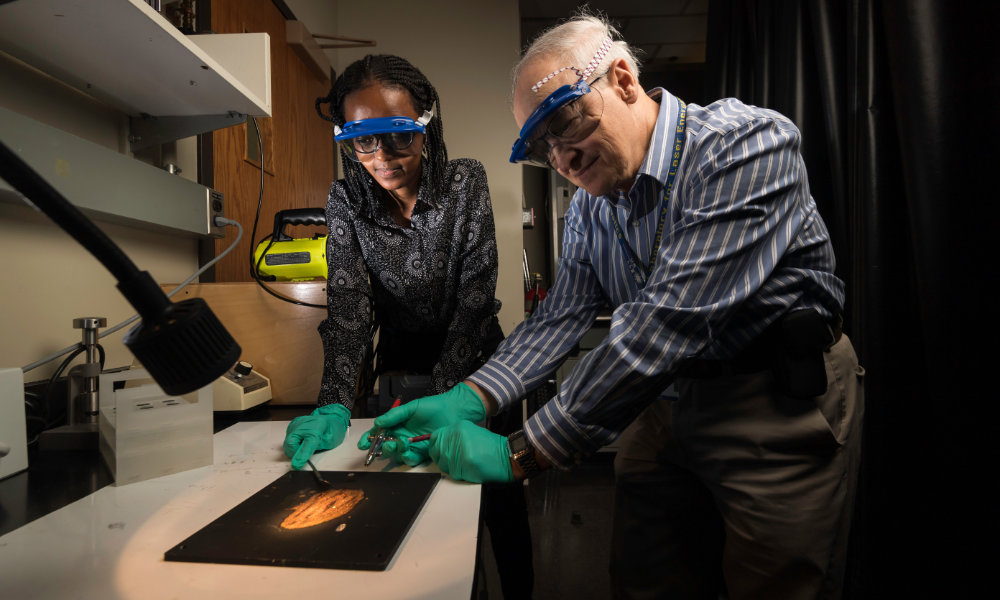 Kenneth Marshall, research engineer at Laser Lab, and Jeanne Lyse Mugeni, student, at work in the lab.