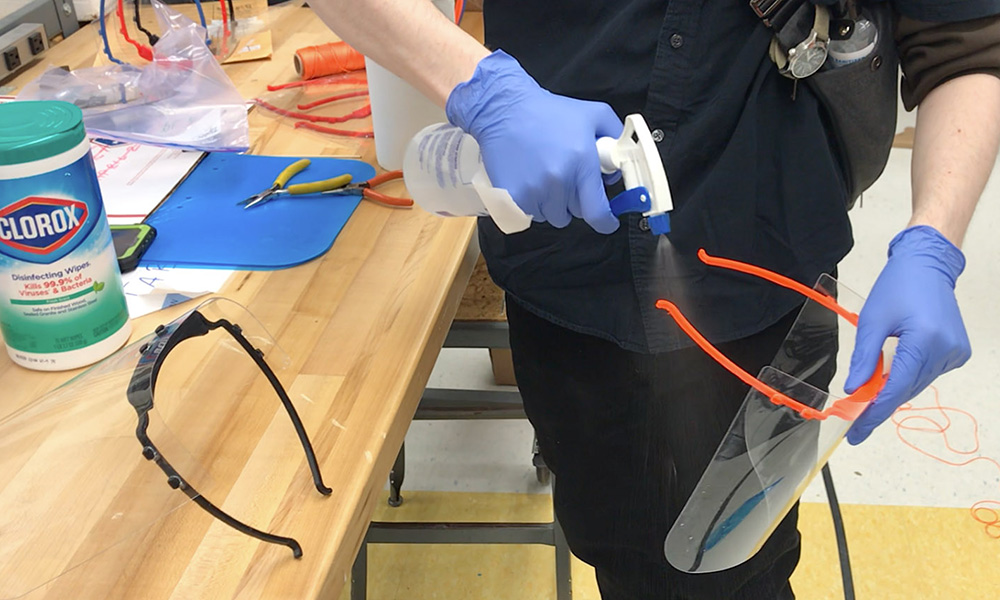 Feature image person sanitizing a face shield