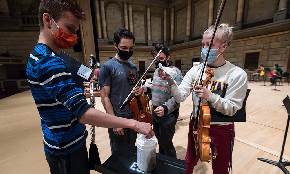 masked music students getting antiseptic wipes