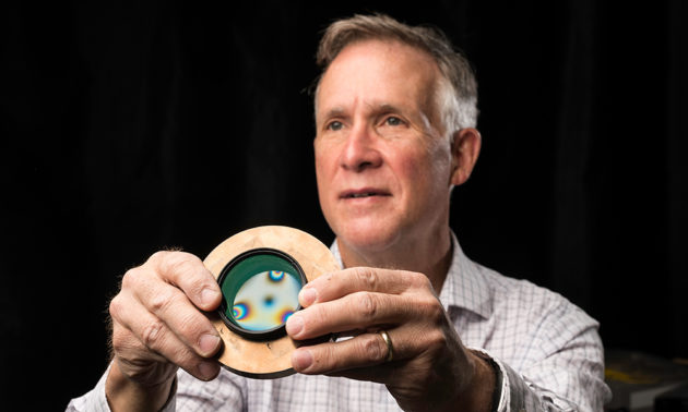 Brown holds up a circular glass plate 