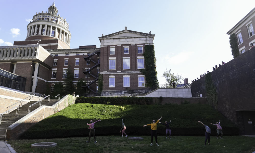 Circle of dancers perform on the Graham Smith Plaza under Rush Rhees Library.