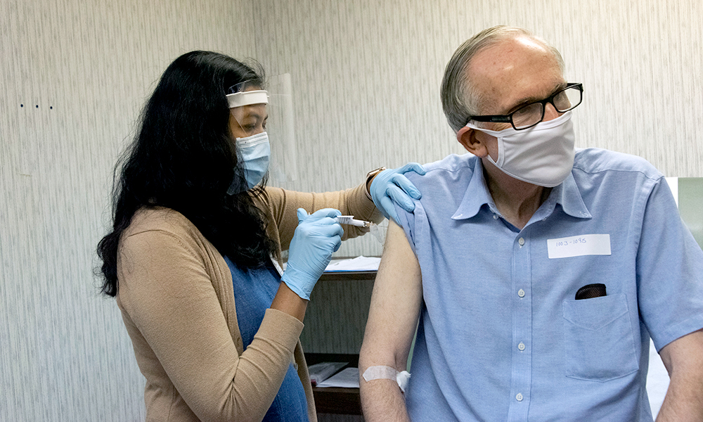 health care worker gives someone a vaccine