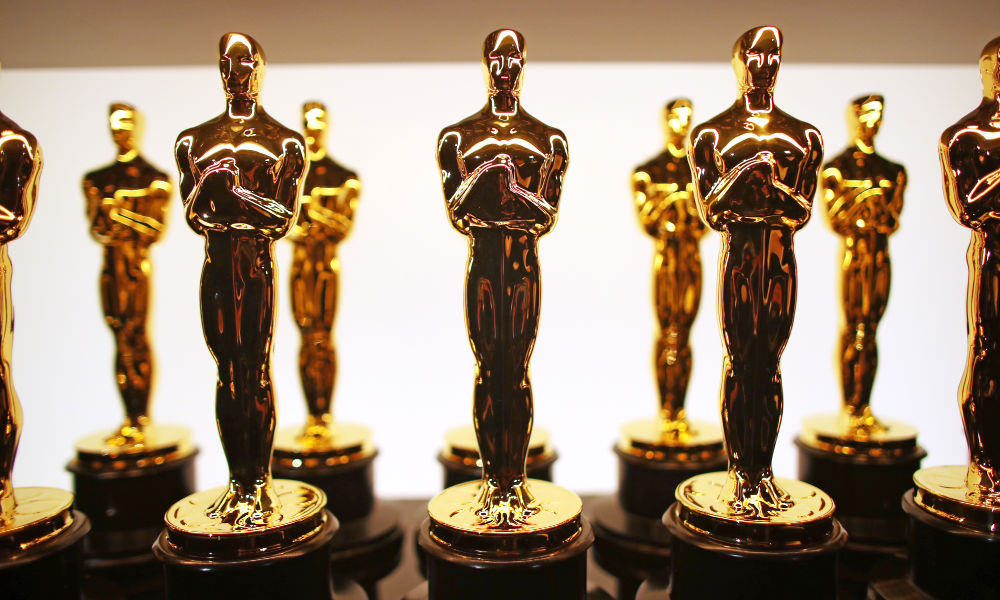 Feature image Two rows of Academy Award statuettes lined up backstage.