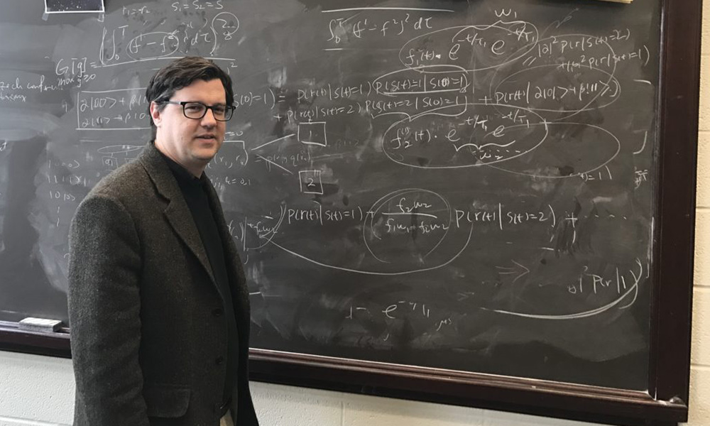 Andrew Jordan standing in front of chalkboard