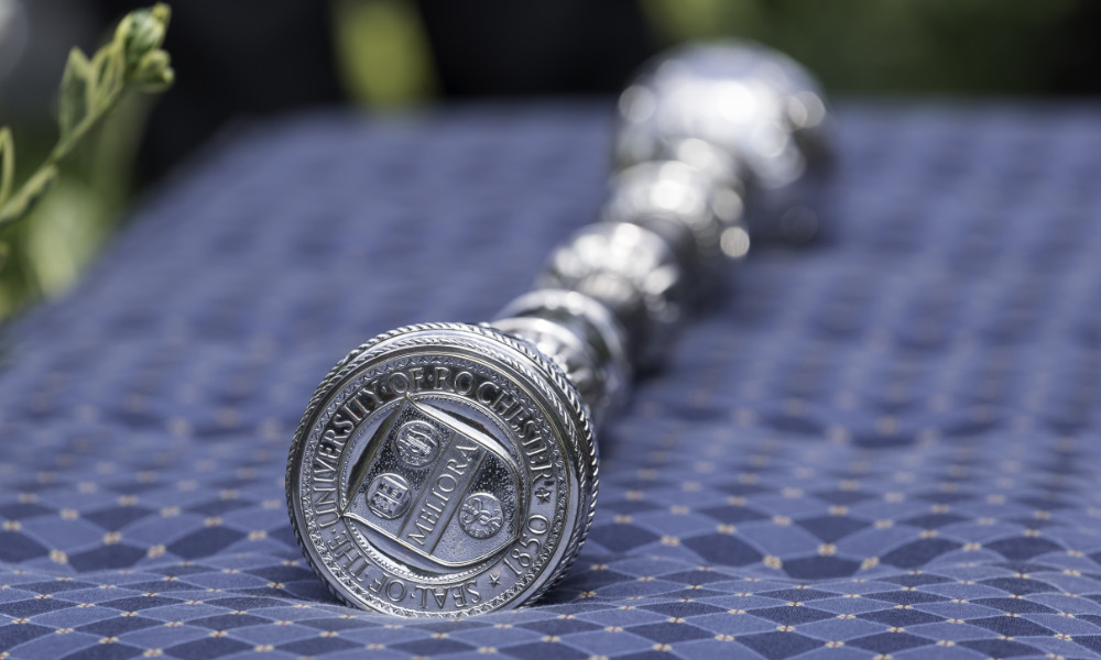 Commencement mace outdoors atop a blue tablecloth.