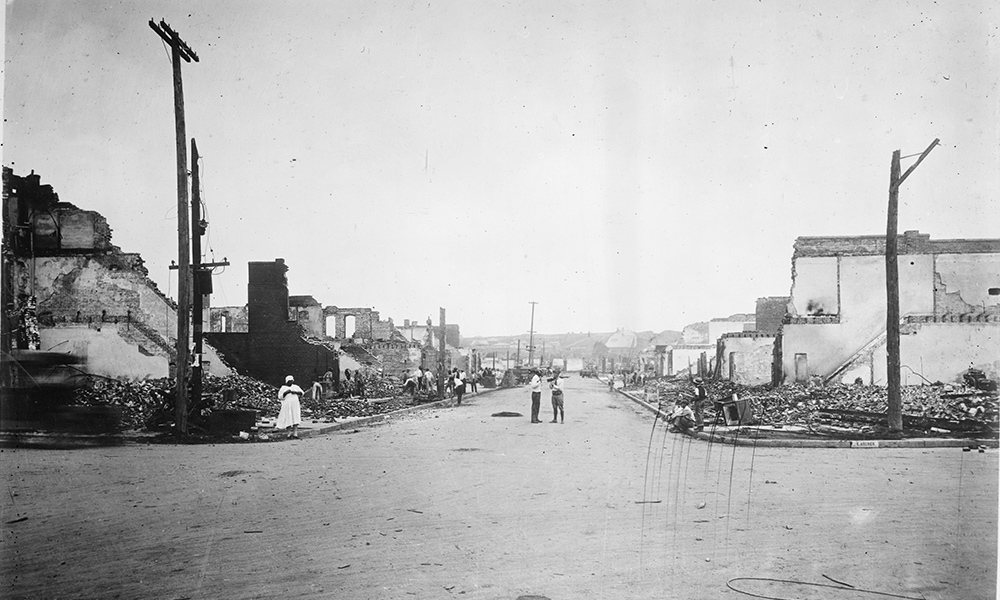 Feature image historical image looking down a street with burned out building lining both sides.