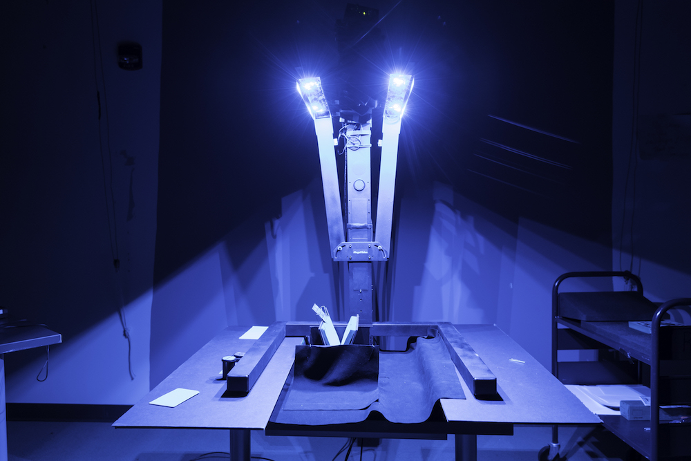 half-open book is propped up under a large blue light