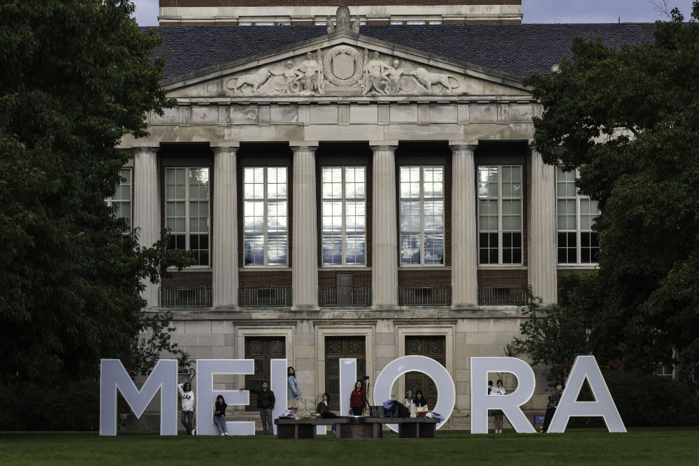 Large letters spell out MELIORA with people posing near them during Meliora 2021.
