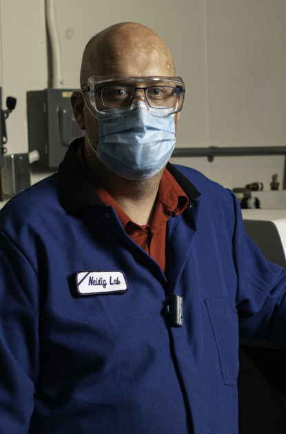 man in blue lab coat, wearing a mask