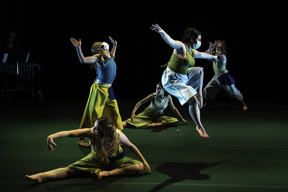 group of 5 dancers lit by stage lights