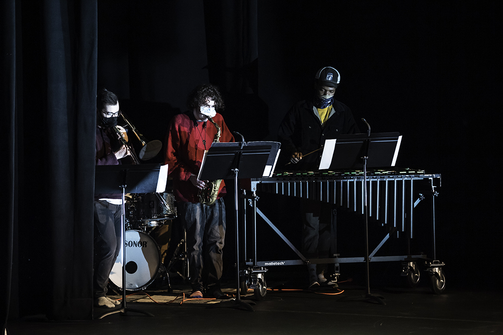three musicians perform on stage