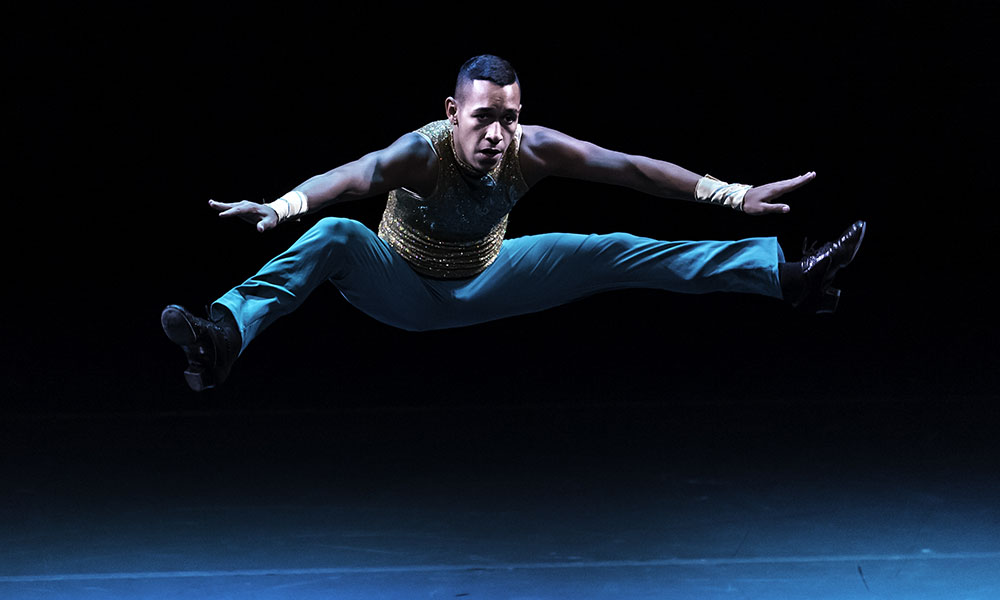 male student dancer catches air during a spirited salsa solo.