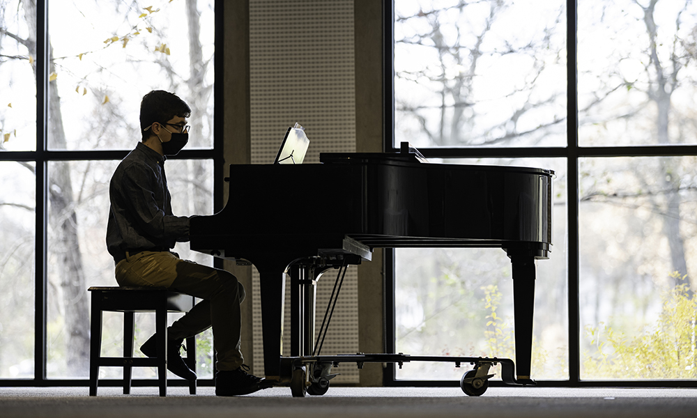 Wide shot of Jacob Rose playing piano.