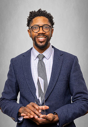 portrait of david paul holding an award