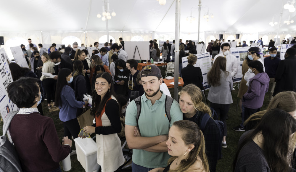Design Day students and attendees under a tent.