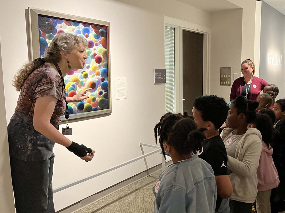 Greaves shows class Trautmann painting during tour of museum.