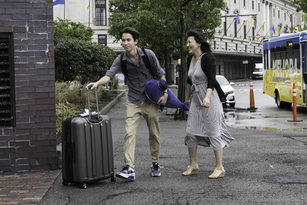 First-year student and parent moving into the Eastman Campus with luggage.