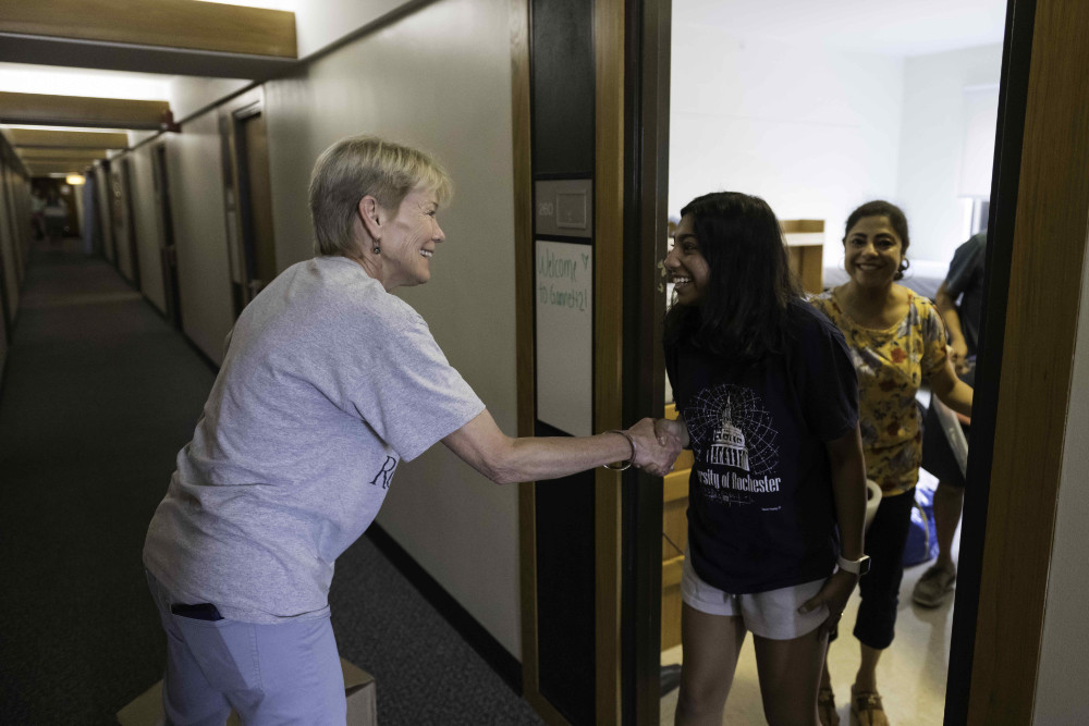Sarah Mangesldorf shakes hands with a first-year student who has moved into her new residence hall.