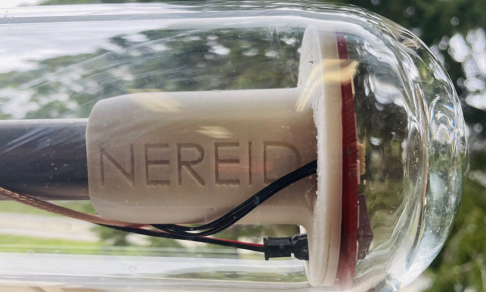 Bioplastic ocean instrument labeled Nereid enclosed in transparent casing.
