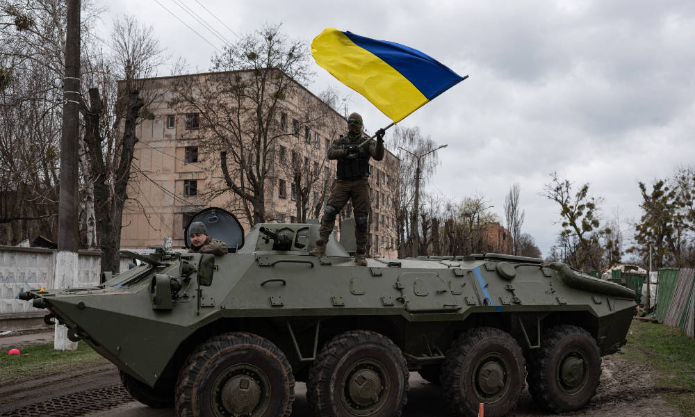Soldier atop a tank waving a Ukrainian flag during as part of a Ukraine war update.