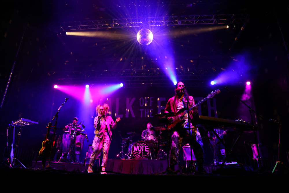 Walk Off the Earth performs on stage under pink and purple lights. 