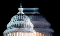 US Capitol dome at night with blurry shadow of itself in background during midterm elections.
