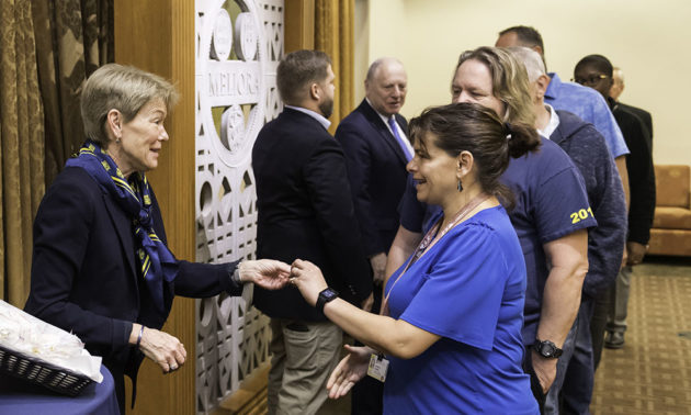 president mangelsdorf hands pin to Jennifer Gaudino.