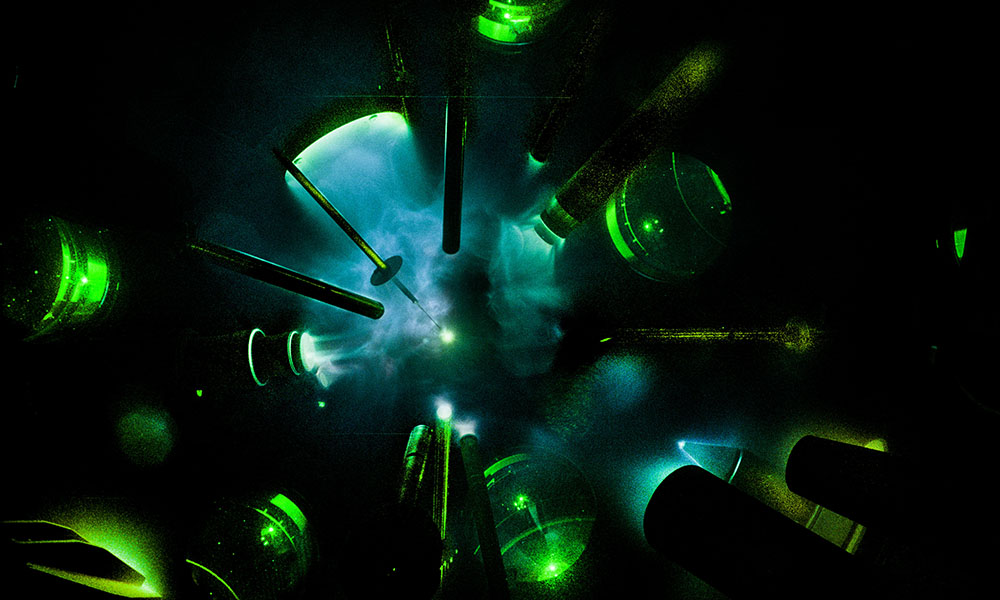 Omega laser array lit in green against black background aiming at target.