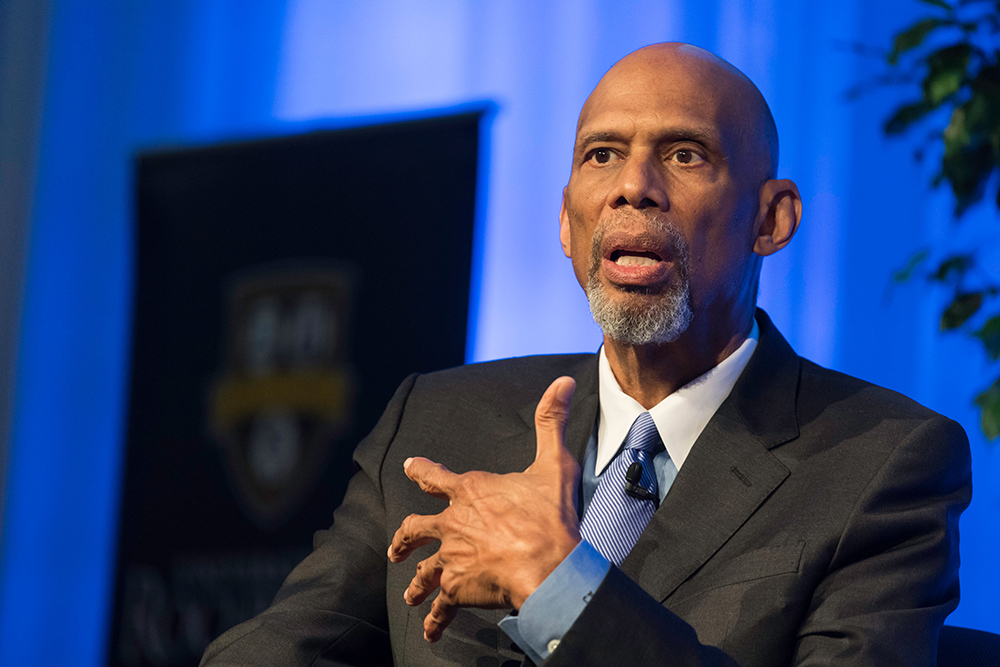 Kareem Abdul speaks while seated on stage at the Palestra.