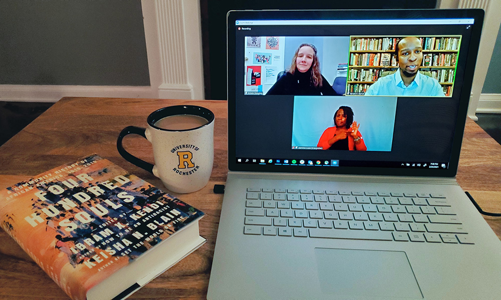 photo of a laptop with Ibram X. Kendi, a sign language interpreter, and a moderator for a Zoom webinar on the screen.