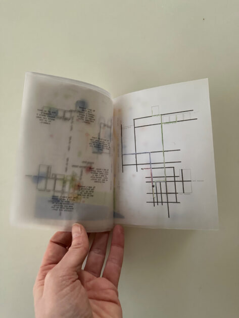 Hand holding open a map book.