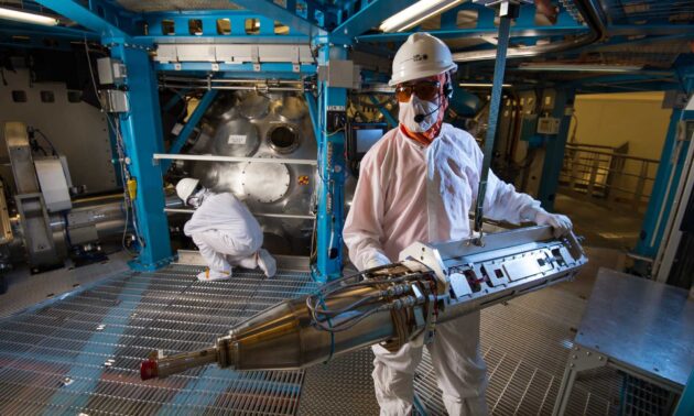 A technician maneuvers a laser diagnostic outside the target chamber of the Omega EP laser at the University of Rochester Laboratory for Laser Energetics.