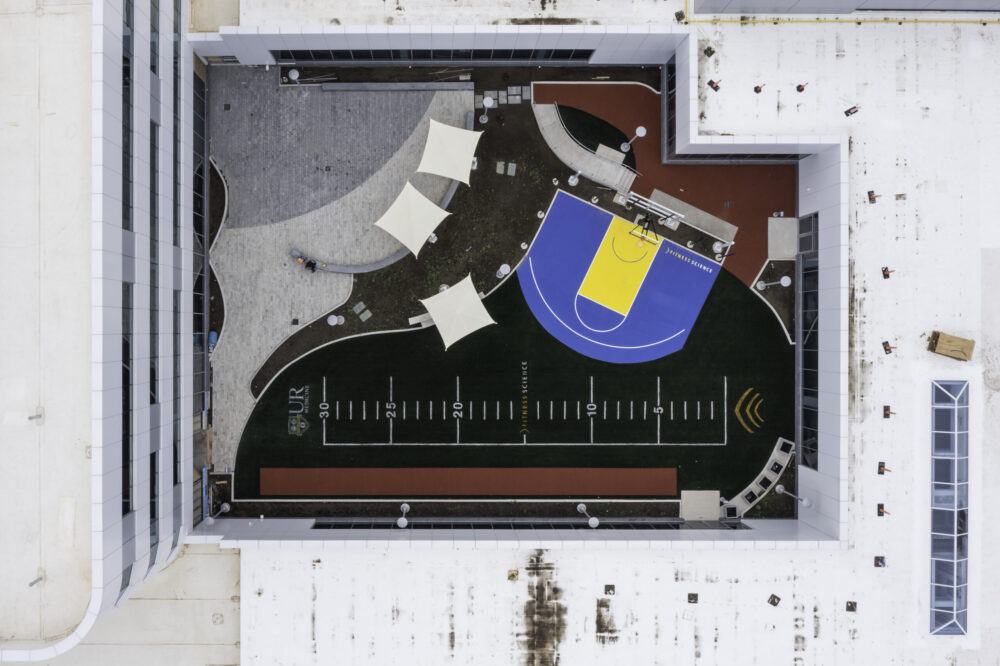 Aerial photo of a building showing a rooftop half-basketball court.