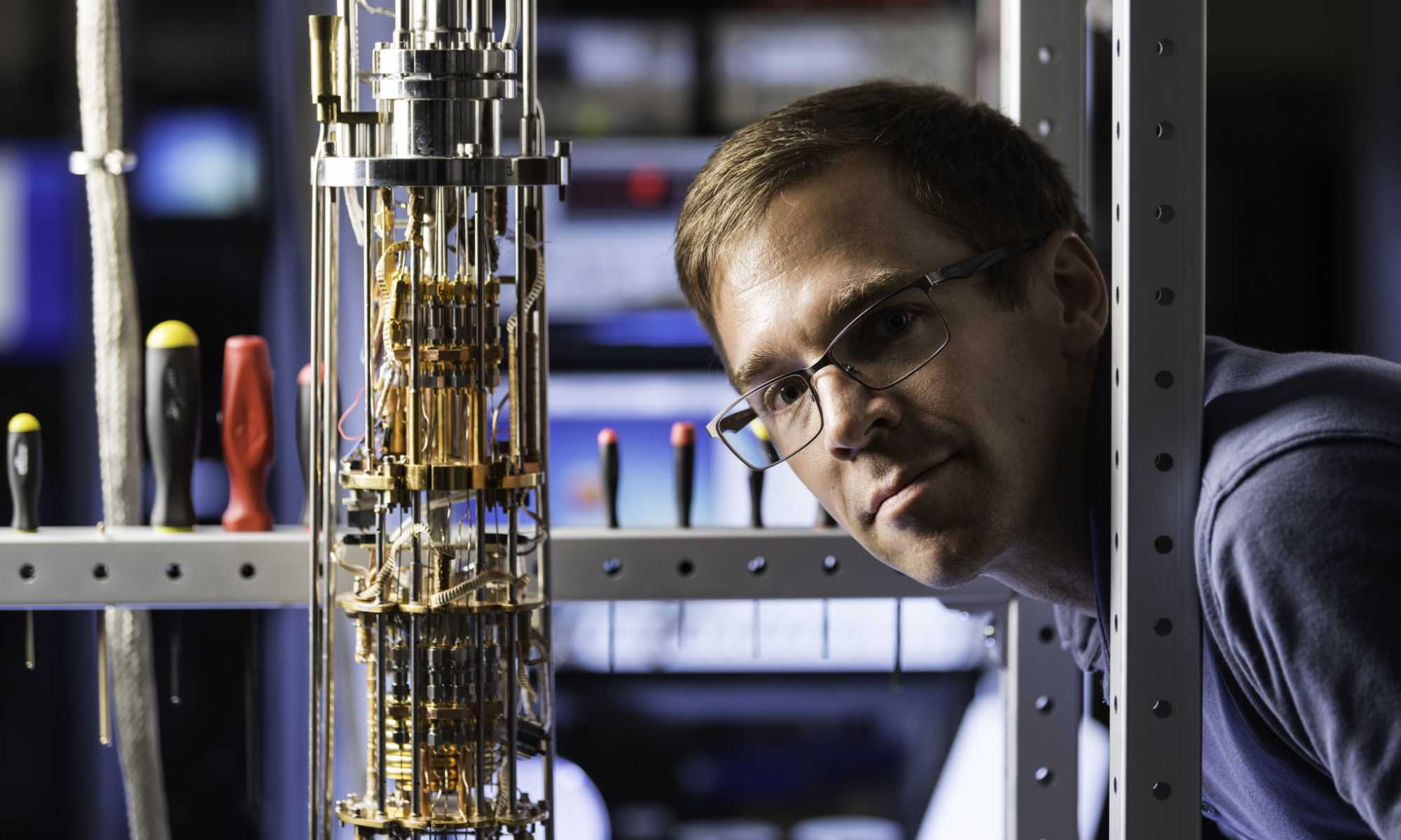 John Nichol faces the camera with his head and shoulders near a dilution refrigerator, which he uses to study thermoelectricity at the nanoscale level.