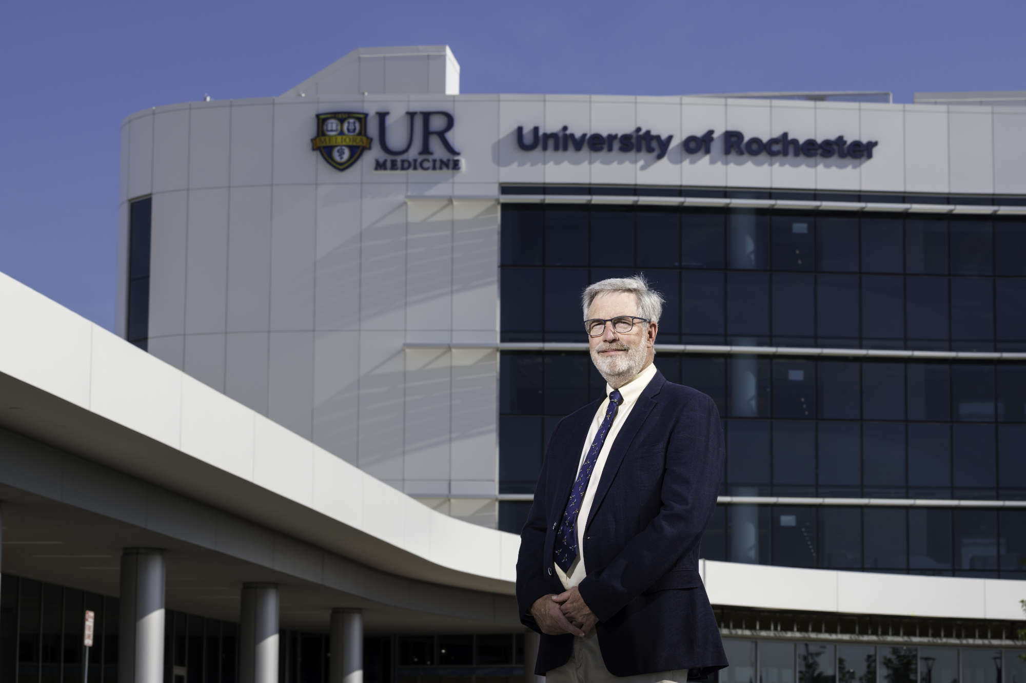 Paul Rubery stands with arms clasped in front of the UR Medicine University of Rochester Orthopedic Center.