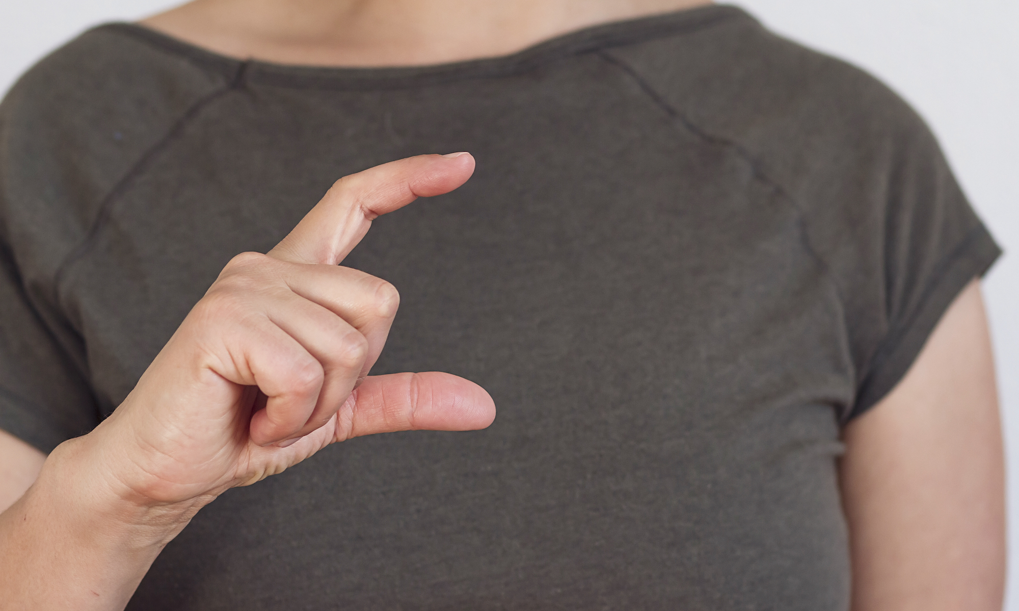 Feature image Woman's hand making gesture used in test for Parkinson's disease.
