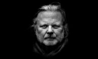 Black and white portrait of Norwegian author and 2023 Nobel Prize for Literature recipient Jon Fosse staring directly at the camera.