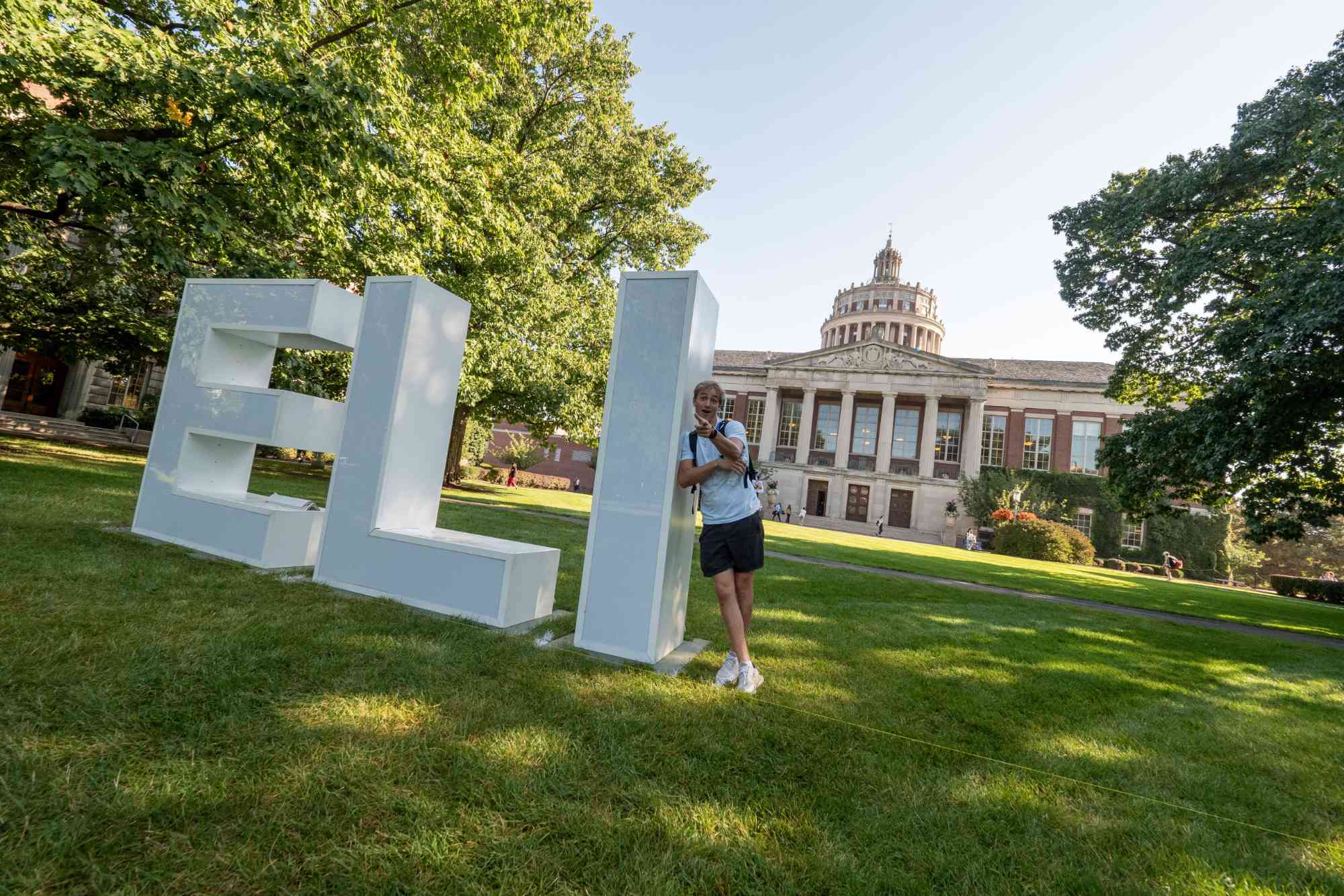 Elijah Barnard leans against giant letters spelling "E-L-I."