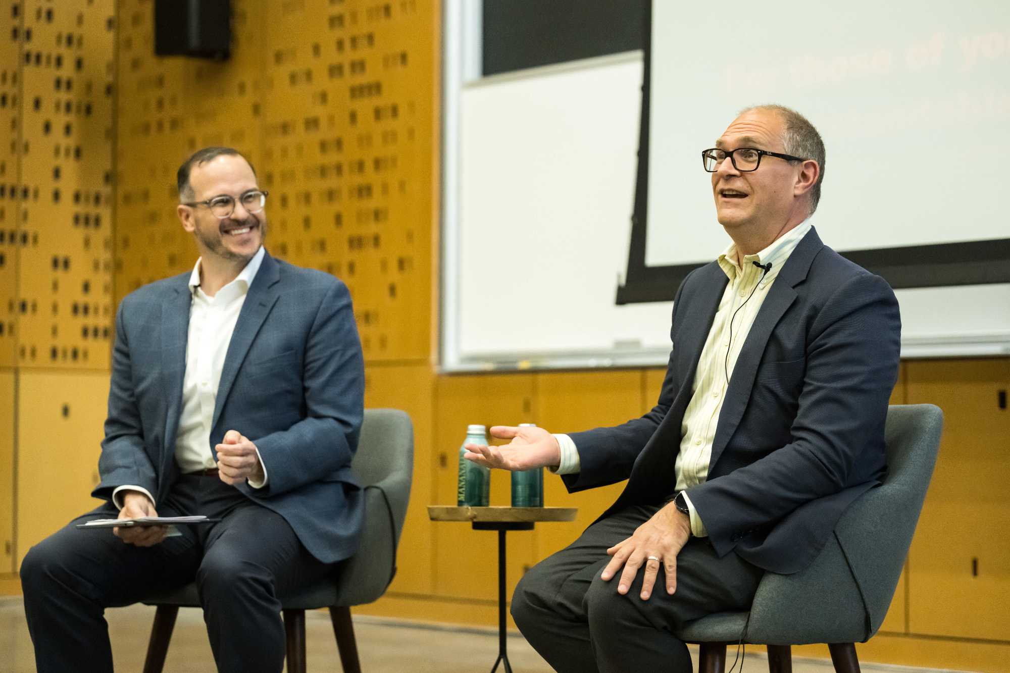 Joe Testani and David Figlio seated in front of a room during a Q-and-A session.