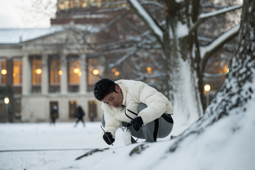 Rongren Zhou of Guangdong, China reacts to seeing snow for the first time by building a snowman 