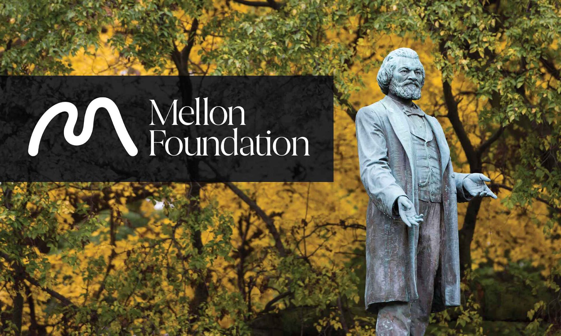 Frederick Douglass statue against the wooded backdrop of Highland Park with an inset of the Mellon Foundation logo displayed in white against black background.