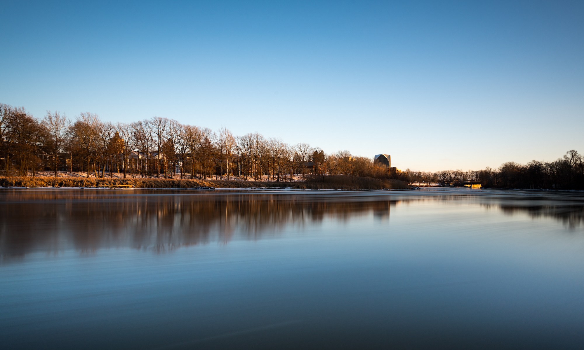 Ice floes float past University of Rochester’s River Campus along the Genesee River during a long exposure at sunset