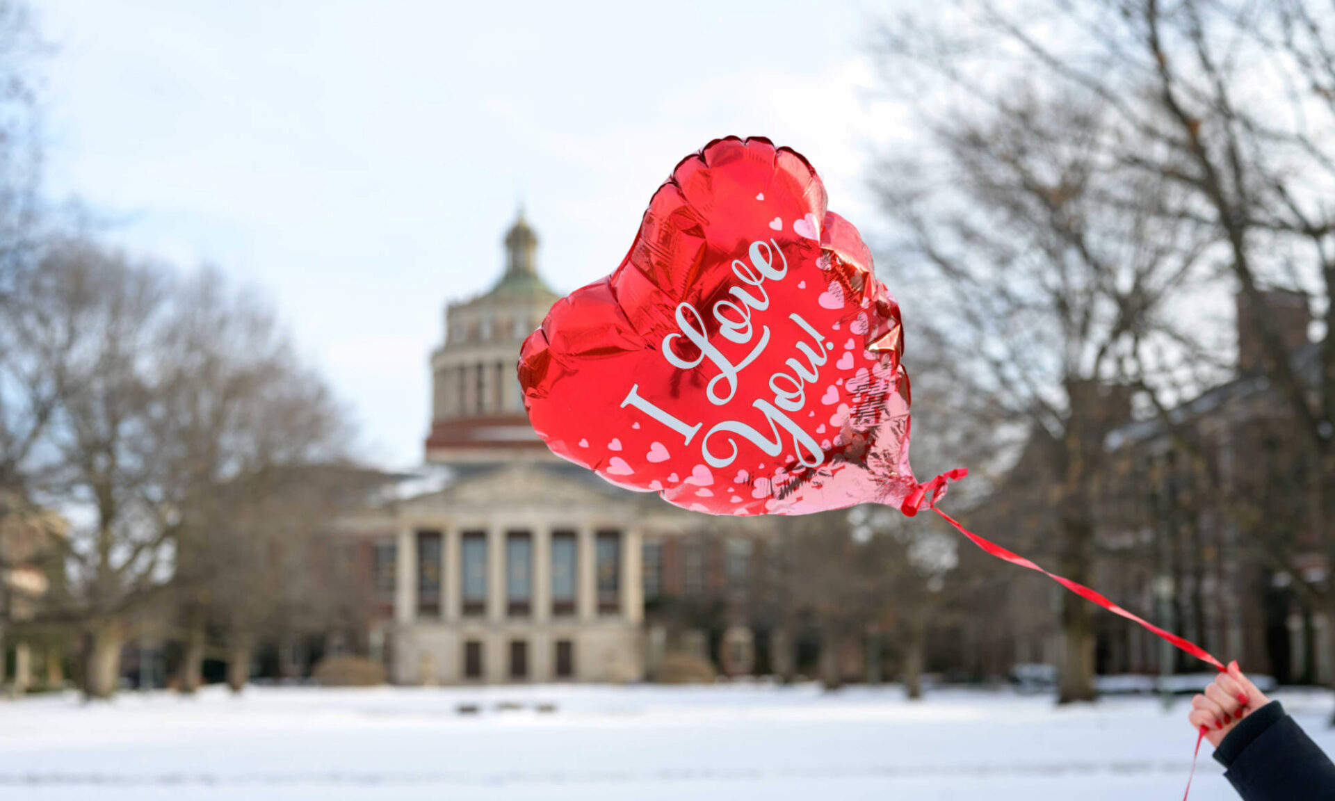 A red, heart-shaped balloon with the words 
