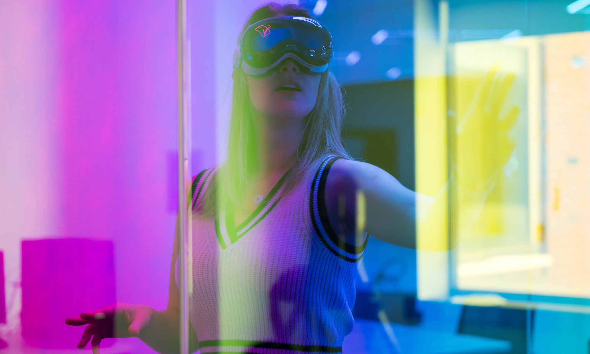 Student uses VR glasses and is pictured through a rainbow prism